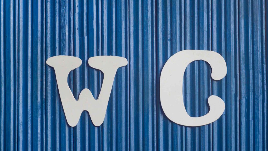 Symbol „WC” ze strzałką kierunkową do toalety.